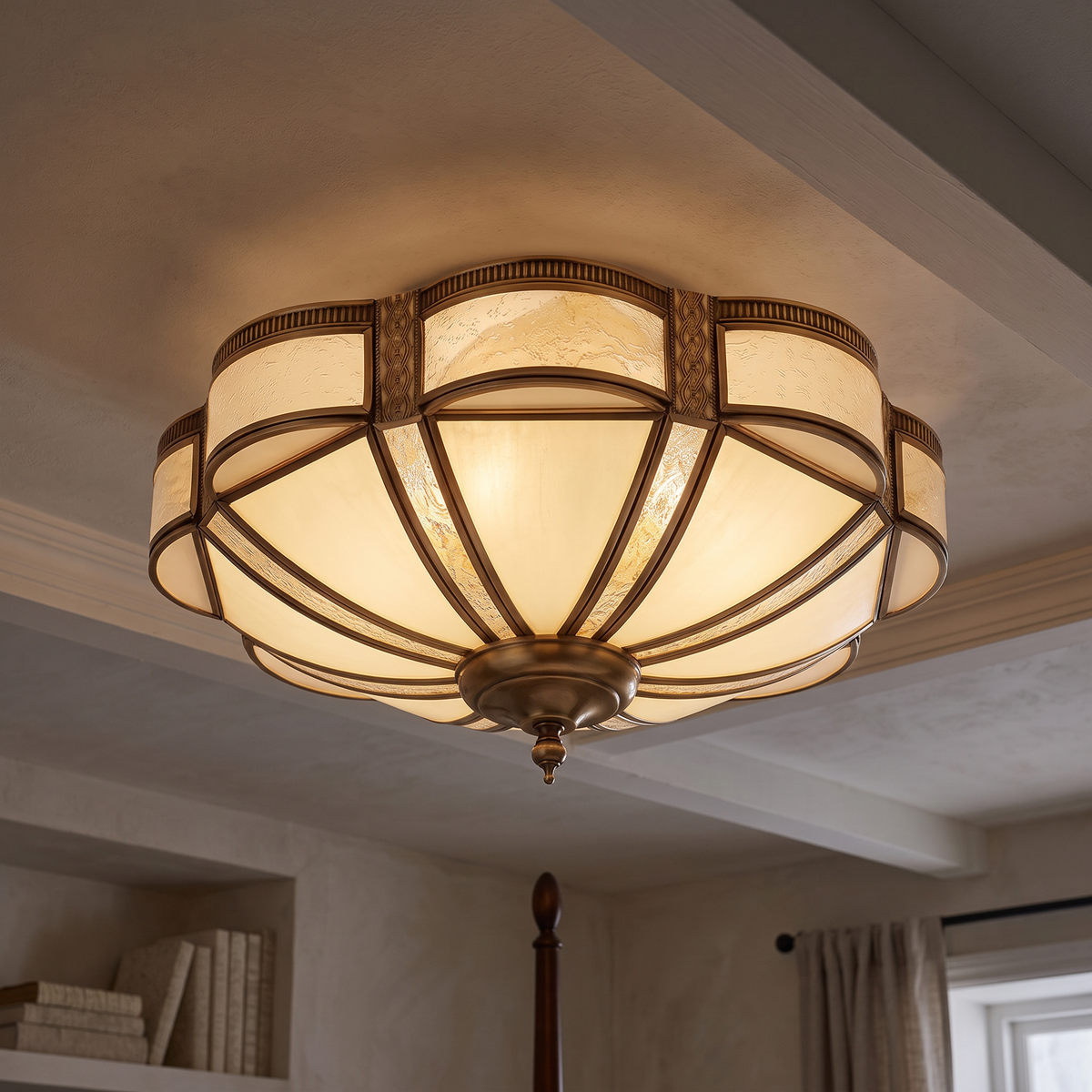 The brass scalloped glass ceiling light lit on the ceiling of a calm bedroom with neutral decor in the evening, camera looking up at the light