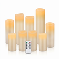 Set of ivory real wax flameless LED pillar candles with remote on a white background